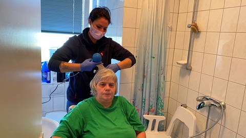 Milena Battle vom Mainzer Pflegedienst föhnt Jeanette Krauß die Haare. 