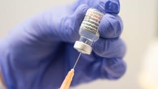 Spritze mit Corona-Impfstoff wird aufgezogen