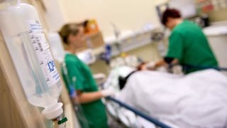 Pflegekräfte versorgen einen Patienten mit Infusionen.