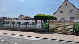 Der komplette Spieplan inklusive Trikots und Symbolen hängt am Zaun: Fußball-EM 2024: Riesiger Spielplan aus Holz in Wörrstadt