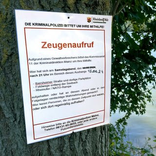 Ein Zeugenaufruf der Polizei hängt an einem Baum am Rhein, Zeugen sollen sich melden. An der Stelle ist das 15-jänhrige Mädchen ertrunken, die Eltern sind tatverdächtig
