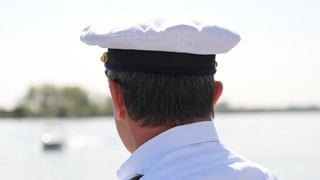 Ein Beamter der Wasserschutzpolizei schaut auf den Rhein. 