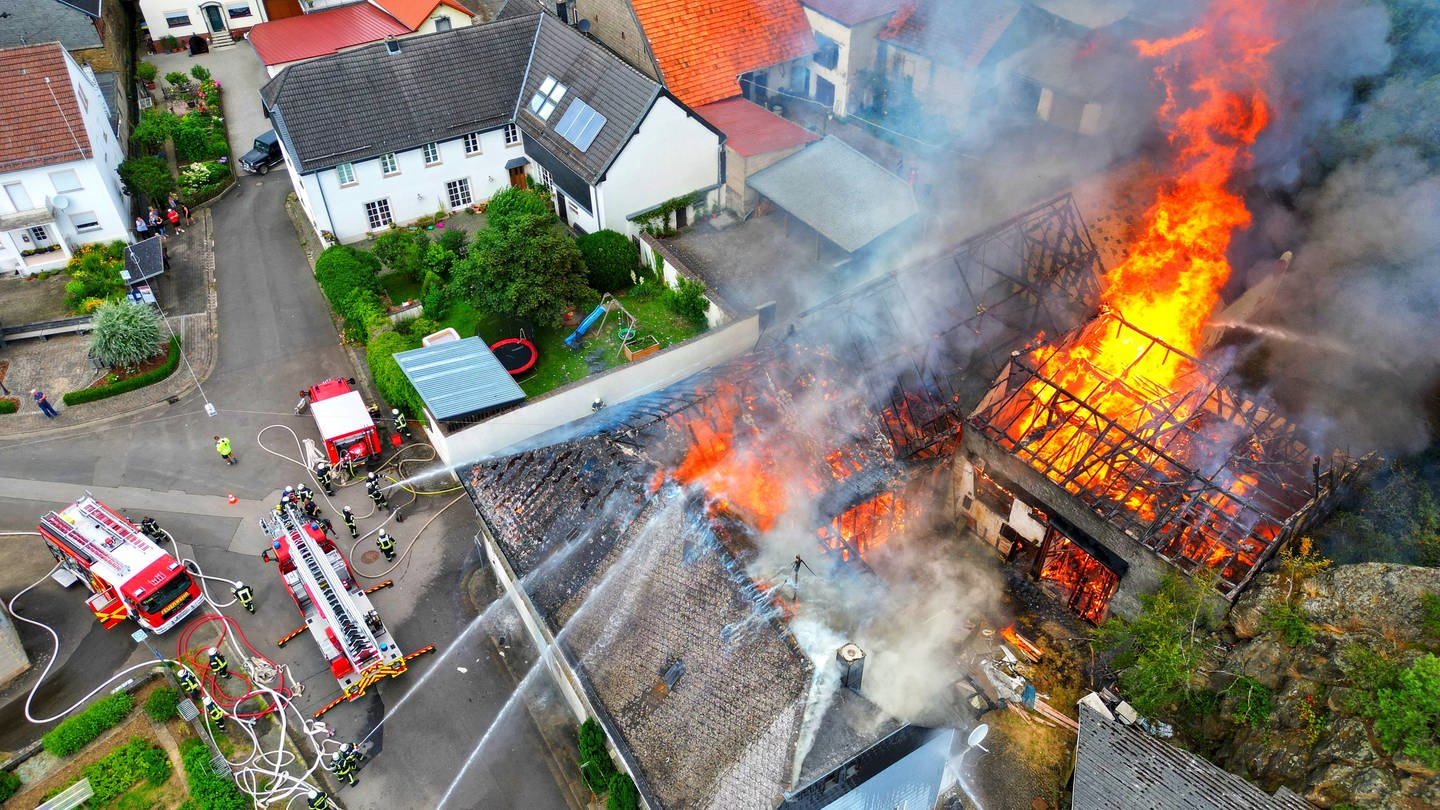 Mehrere Gebäude eines Hofes in Seesbach (Kreis Bad Kreuznach) stehen lichterloh in Flammen.