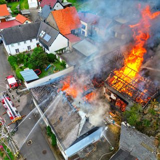 Mehrere Gebäude eines Hofes in Seesbach (Kreis Bad Kreuznach) stehen lichterloh in Flammen.