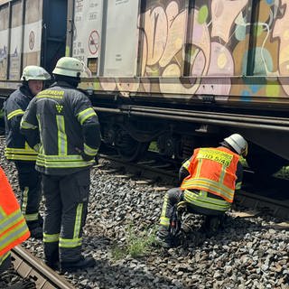 Feuerwehrleute überprüfen im Rheingau die Bremsen eines Güterzuges, nachdem er mehrere Brände verursacht hat.