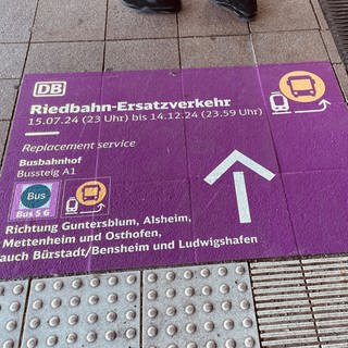 Hinweise auf dem Boden leiten die Fahrgäste am Wormser Hauptbahnhof zum Riedbahn-Ersatzverkehr. (SWR)