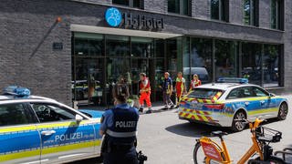 Fahrzeuge der Polizei stehen vor einem Hotel in Mainz.