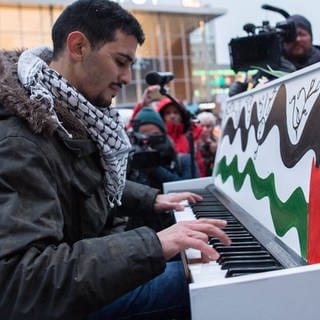 Der syrisch-palästinensische Musiker Aeham Ahmad spielt Klavier, um gegen den Gaza-Krieg zu protestieren.
