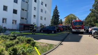 Einsatzkräfte der Feuerwehr Bad Kreuznach vorm Eingang eines Mehrfamilienhauses