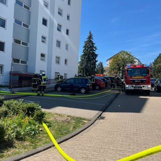 Einsatzkräfte der Feuerwehr Bad Kreuznach vorm Eingang eines Mehrfamilienhauses