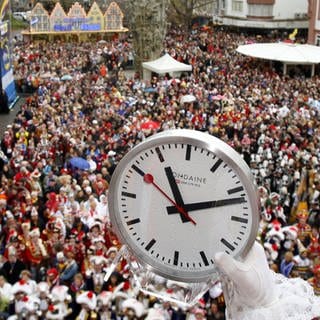 Ein Foto vom Schillerplatz in Mainz mit feiernden Menschen und einer Uhr für den Countdown am 11.11., der SWR überträgt die Veranstaltung