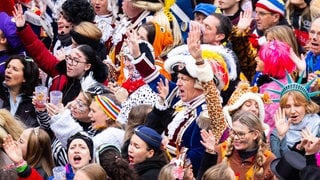 Verkleidete Narren und ein Gardist rufen "Helau" am 11.11. auf dem Mainzer Schillerplatz.