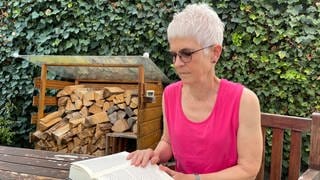 Die ehrenamtliche Sterbebegleiterin Cornelia Boller liest auf ihrer Terrasse in Mainz ein Buch.