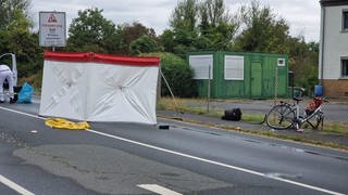 An der Unfallstelle wird der verunglückte Radfahrer mit einem Sichtschutz abgeschirmt