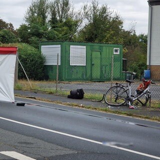 An der Unfallstelle wird der verunglückte Radfahrer mit einem Sichtschutz abgeschirmt