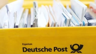 Briefe liegen in einer gelben Postbox.