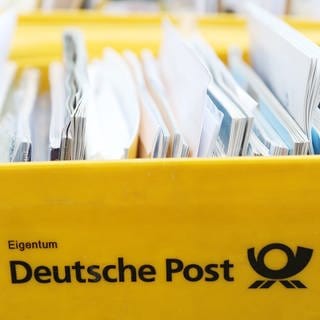 Briefe liegen in einer gelben Postbox.