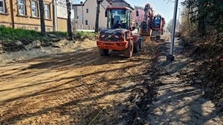 Bagger stehen auf einer Straße in Monsheim, der Beton wurde bereits entfernt.