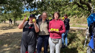 Winzerin Ute Schweinhardt mit Mitarbeitenden der Lebenshilfe Werkstätten Bad Kreuznach - sie hat der Gruppe nach dem Diebstahl die Ernte ihrer eigenen Apfel-Plantage geschenkt.