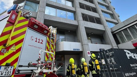 Da müssen sie hoch: Feuerwehrleute schauen hoch zu den Mainzer Bonifazius-Türmen - kurz vor dem Towerrun.