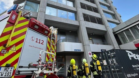 Da müssen sie hoch: Feuerwehrleute schauen hoch zu den Mainzer Bonifazius-Türmen - kurz vor dem Towerrun