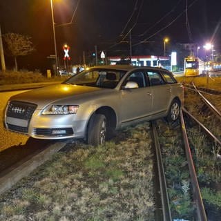 Ein Auto liegt im Gleisbett, eine Straßenbahn muss warten. In Mainz ist ein Autofahrer geflohen, nachdem er mit dem Wagen im Gleisbett hängen geblieben ist. 