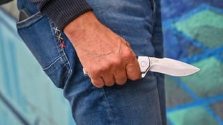 Mann hält eine Messer in der Hand. Bei der Attacke in Worms wurde ein Mann leicht verletzt. 