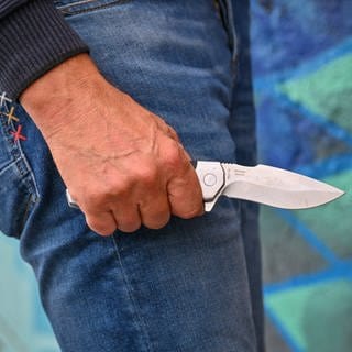 Mann hält eine Messer in der Hand. Bei der Attacke in Worms wurde ein Mann leicht verletzt. 