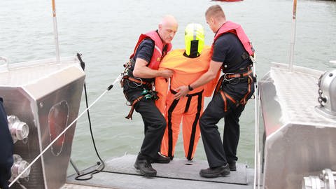 Zwei Feuerwehrmänner der Feuerwehr Bingen ziehen die Übungspuppe an Deck. 