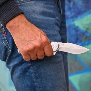 Ein Mann mit einem Messer in der Hand. Am Wormser Hauptbahnhof hat die Polizei einen Mann gefasst, der mit einem Messer mehrere Menschen bedroht hat. (Symbolbild) 