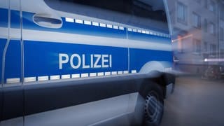 Ein Polizeiauto steht vor einem Haus. (Symbolbild) In Mainz hat die Polizei die Wohnung eines Mannes durchsucht, der den Hamas-Terror im Internet verherrlicht haben soll. 