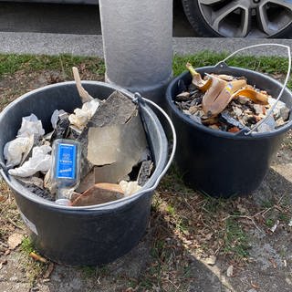 Zwei Eimer mit Bauschutt. (Symbolbild) In Worms steht ein Mann vor Gericht, der mit einem Beil auf einen Jäger losgegangen sein soll. 