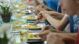 Schüler sitzen beim Essen in der Mensa.