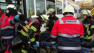 Rettungskräfte betreuen einen Mann nach einem Straßenbahnunglück in Mainz. Es handelt sich um eine nachgestellte Szene, um den Ernstfall zu proben.