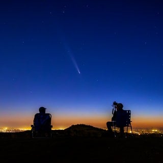 Der Komet C2023 A3 (Tsuchinshan-ATLAS) ist am Nachthimmel zu sehen, während ihn zwei Amateurfotografen beobachten.