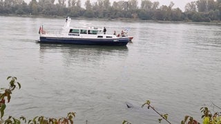 Die Wasserschutzpolizei begleitet von einem Schiff aus die Bergung des Autos im Rhein.