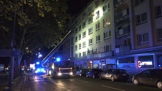 Feuerwehr mit Drehleiter vor einem Haus in Mainz. Ein Mensch wurde hier bei einem Brand lebensgefährlich verletzt