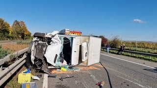 Ein Transporter liegt nach dem Unfall auf der A63 bei Saulheim stark beschädigt auf der Seite. 