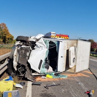 Ein Transporter liegt nach dem Unfall auf der A63 bei Saulheim stark beschädigt auf der Seite. 