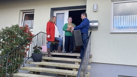 Die Kundin des Dorfladens in Winterbach übernimmt ihre Waren an der Haustür.