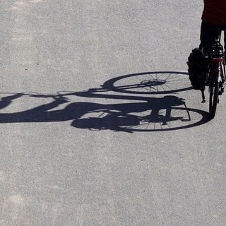 Fahrrad mit langem Schatten. Der Radfahrer war auf der Autobahn bei Bad Kreuznach unterwegs. 