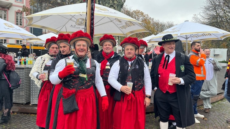 Eine Gruppe von Männer trägt die Schwarzwald-Tracht der Frauen - mit Bollenhut. 