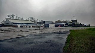 Ein Blick auf die Gebäude des Flugplatzes Worms bei schlechtem Wetter. Es ist trüb und regnerisch.