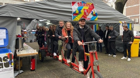 Studierende der Hochschule Mainz fahren auf ihrem Tandem, das den Fastnachtswagen am Rosenmontag ziehen soll.