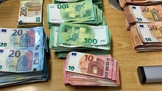 Auf einem Tisch liegen 83 900 Euro Bargeld in Scheinen, die die Polizei beschlagnahmt hat. Das Foto ist ein Symbolbild.