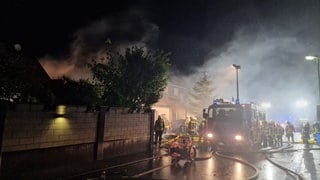 Feuerwehrleute löschen den Brand eines Hauses in Gau-Odernheim, das nach einem Sauna-Brand Feuer gefangen hatte.