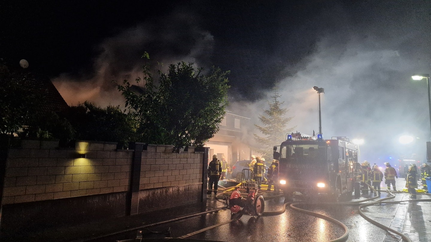 Feuerwehrleute löschen den Brand eines Hauses in Gau-Odernheim nach einem Feuer in der Sauna.