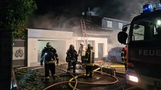 Feuerwehrleute löschen den Brand eines Hauses in Gau-Odernheim nach einem Feuer in der Sauna.