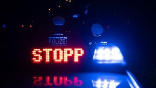 Das Wort "Stopp" ist auf dem Dach eines Polizeiwagens zu lesen.