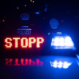 Das Wort "Stopp" ist auf dem Dach eines Polizeiwagens zu lesen.